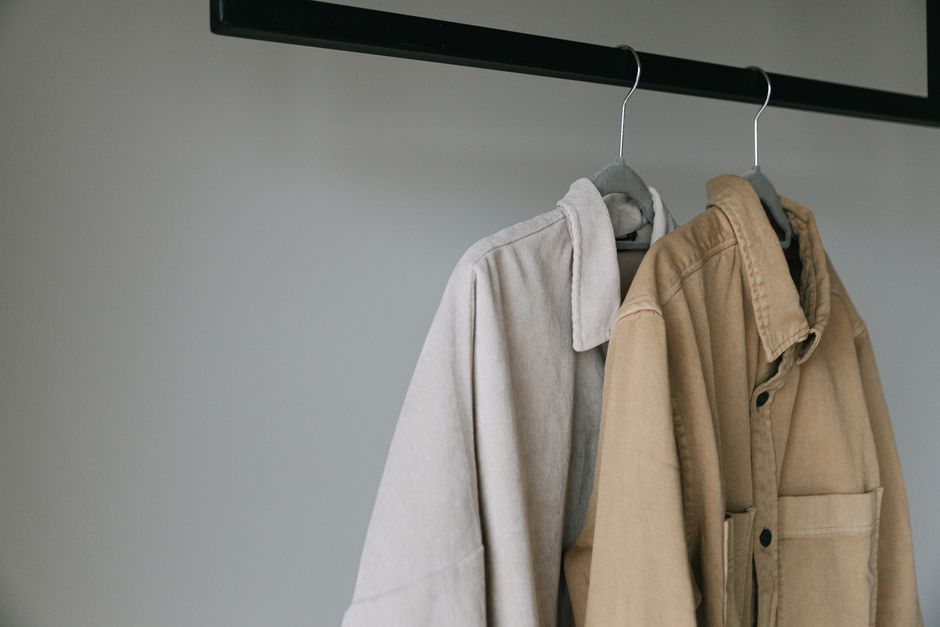 Close-up of beige shirts on hangers, showcasing minimalist style.