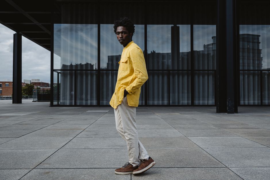 Urban portrait of a man in yellow jacket against modern architecture in Berlin.