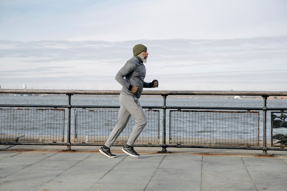 Elderly man running along waterfront, embracing a healthy lifestyle and exercise routine.