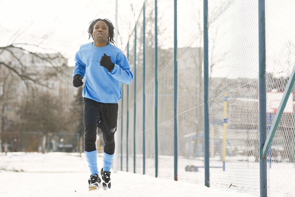A young man jogging on a snowy day, embracing the winter workout routine.