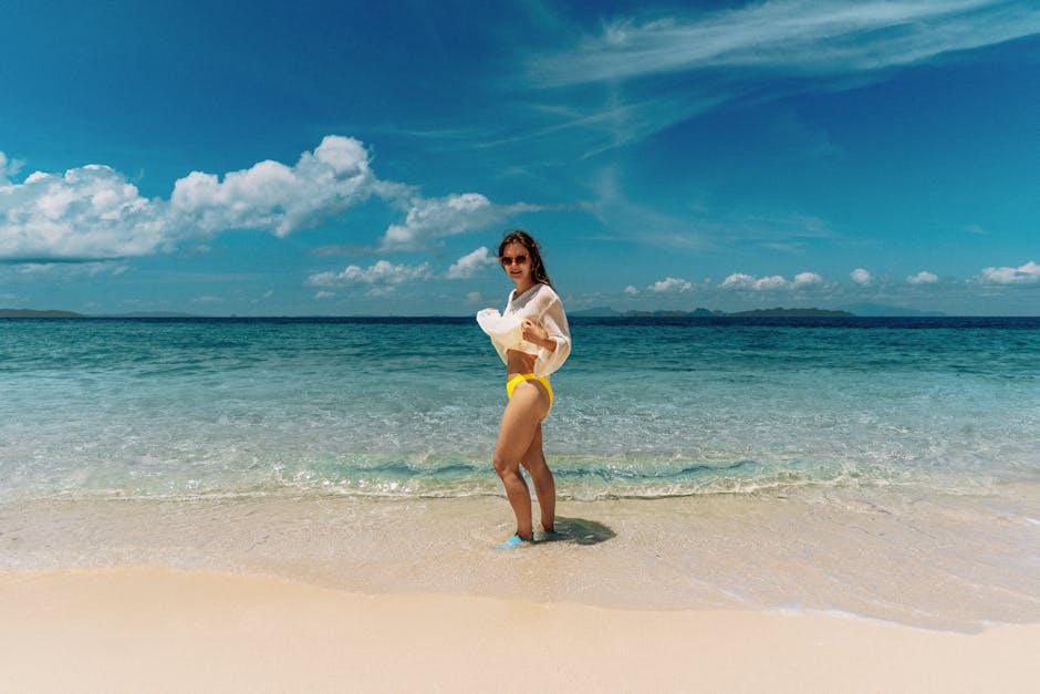 A woman in yellow swimwear enjoys the sunny beach at Tambon Ao Nang, Krabi, Thailand.