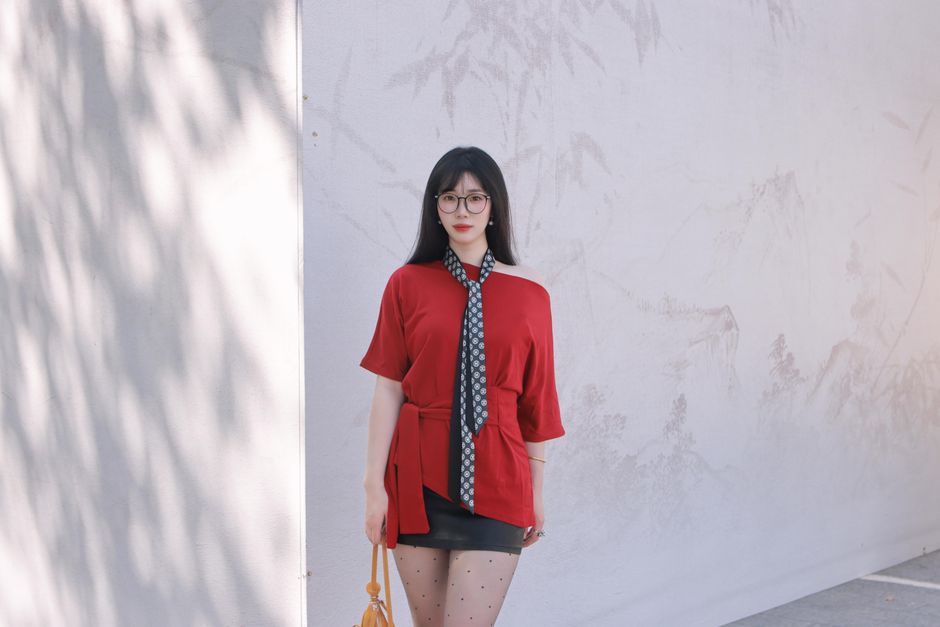 Stylish woman in red top and polka dot stockings poses outdoors in Nanjing, China.