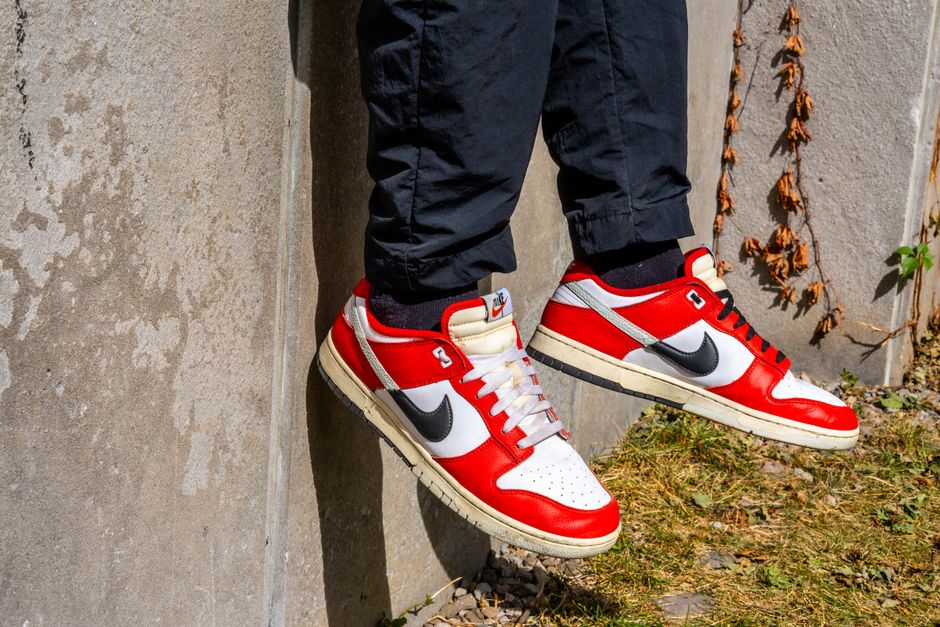 Vibrant red and white sneakers showcased against a raw urban backdrop.