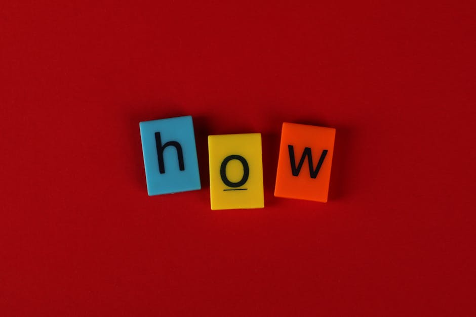 Colorful letter tiles spelling 'How' on a vibrant red background, ideal for educational content.